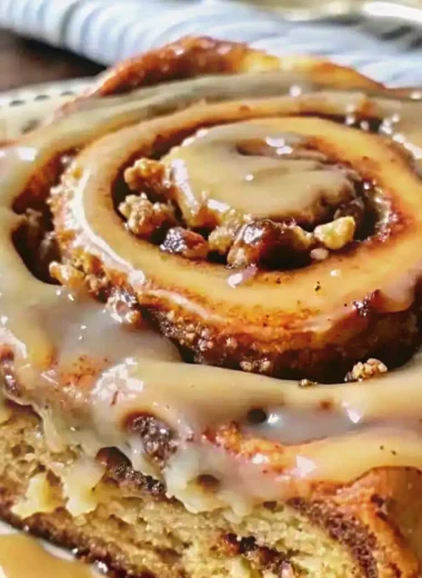 A freshly prepared Banana Bread Cinnamon Rolls recipe with golden swirls, ripe banana filling, and creamy yogurt glaze, served warm on a white plate