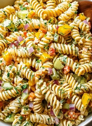 Bowl of Dill Pickle Pasta Salad garnished with fresh dill and pickles.