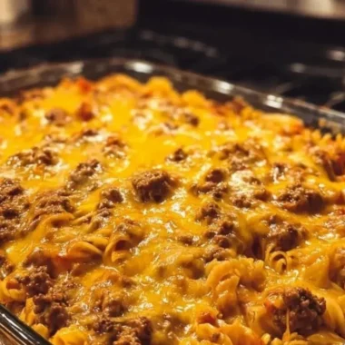 Cheeseburger pasta casserole topped with melted cheese and fresh herbs