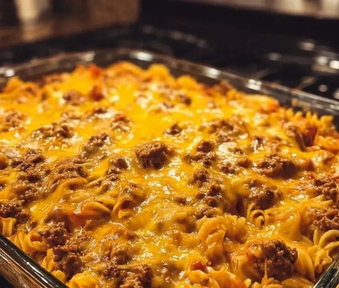 Cheeseburger pasta casserole topped with melted cheese and fresh herbs