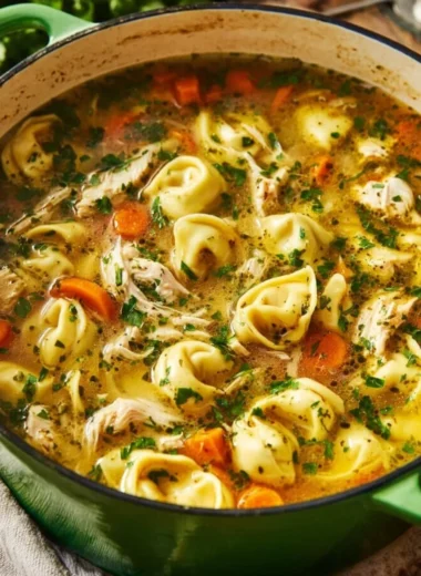 Bowl of Chicken Tortellini soup with fresh herbs and vegetables
