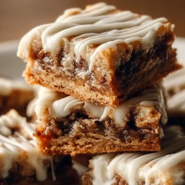 Cinnamon Roll Bliss Bars topped with icing and cinnamon, perfect for dessert.