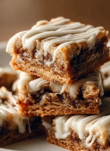 Cinnamon Roll Bliss Bars topped with icing and cinnamon, perfect for dessert.