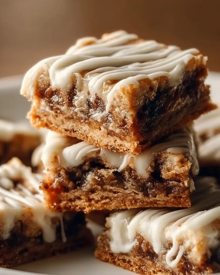 Cinnamon Roll Bliss Bars topped with icing and cinnamon, perfect for dessert.