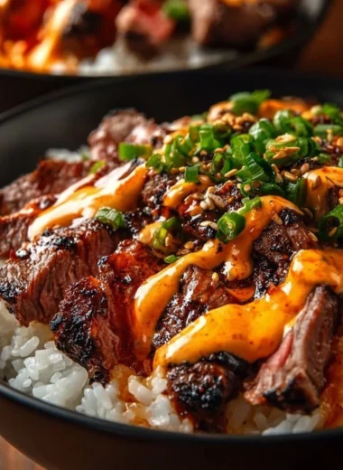 Korean BBQ Steak Rice Bowls with Spicy Cream Sauce on a wooden table