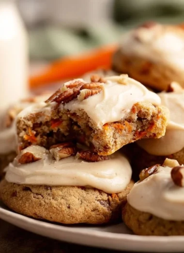 Delicious carrot cake cookies with cream cheese frosting on a plate.