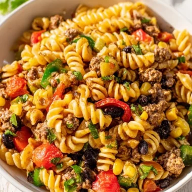 Colorful Cowboy Pasta Salad with fresh vegetables and dressing in a bowl