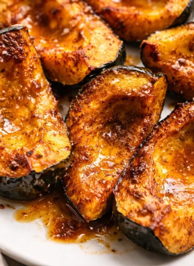 Roasted acorn squash halves with brown sugar and butter, served as a fall side dish