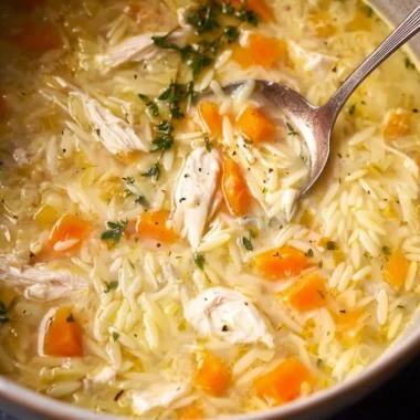 Bowl of easy lemon chicken orzo soup garnished with fresh herbs