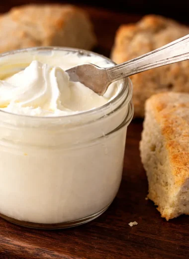 Thick and creamy clotted cream spread on scones with a rich texture.