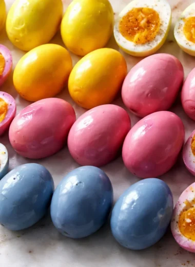 Colorful pickled eggs in a jar with vibrant brine made from beets and spices.