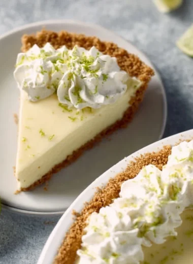 Slice of ultimate key lime pie with vibrant lime topping on a plate