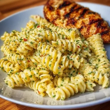 Plate of creamy Garlic Parmesan Chicken Pasta garnished with parsley.