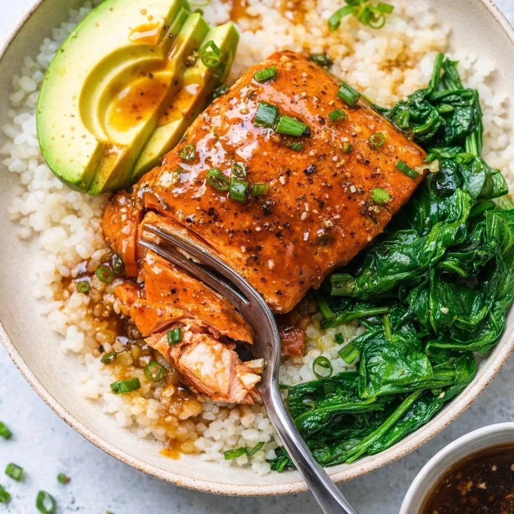 Teriyaki salmon rice bowl with vegetables and garnishes