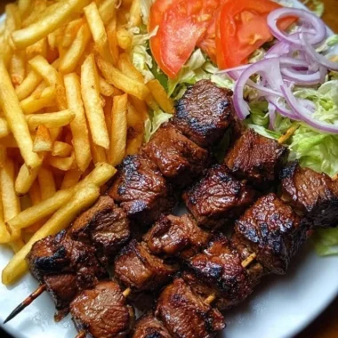Crispy grilled beef skewers accompanied by fries and garden salad