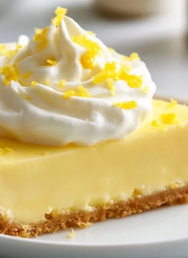 Classic lemon tart topped with fresh lemon slices and mint leaves.