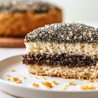 Slice of creamy poppy seed cake topped with a light frosting