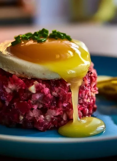 A plate of Labskaus, showcasing the vibrant mix of meat, potatoes, and beets.