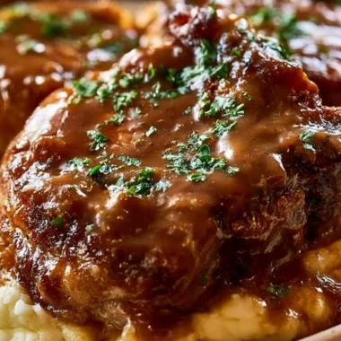 Smothered pork chops served with creamy sauce and vegetables on a plate