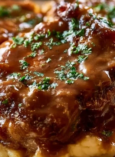 Smothered pork chops served with creamy sauce and vegetables on a plate