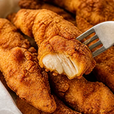 Golden brown crispy chicken tenders served with dipping sauce
