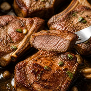 Deliciously baked lamb loin chops served on a plate with fresh herbs